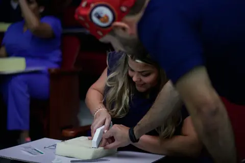 Participante practica una sutura sobre un modelo de silicona