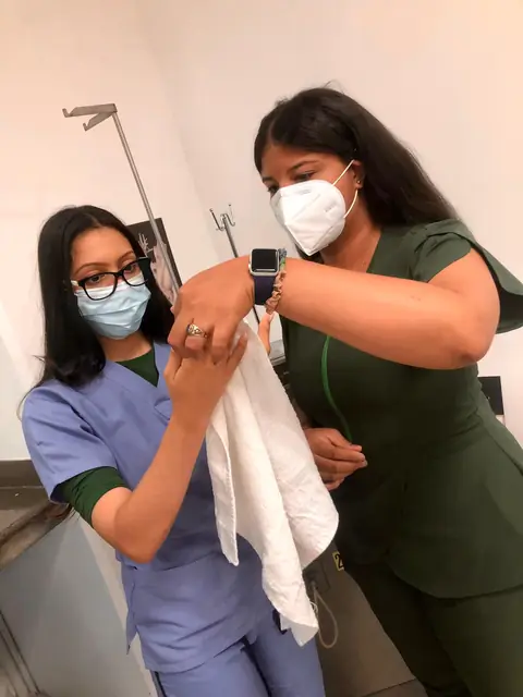 Instructora guía a una estudiante en la colocación de un vendaje
