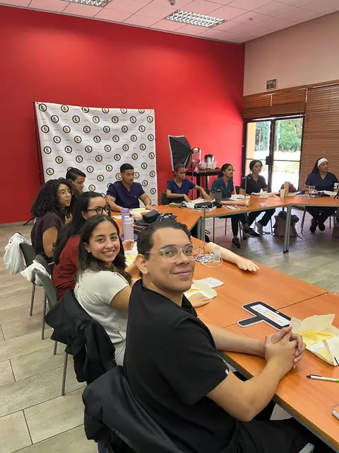 Participantes trabajan en un taller práctico alrededor de una mesa