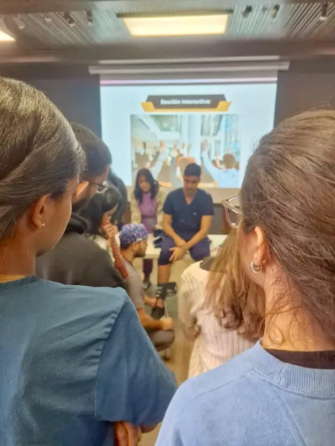 Participantes siguen una sesión interactiva proyectada en pantalla
