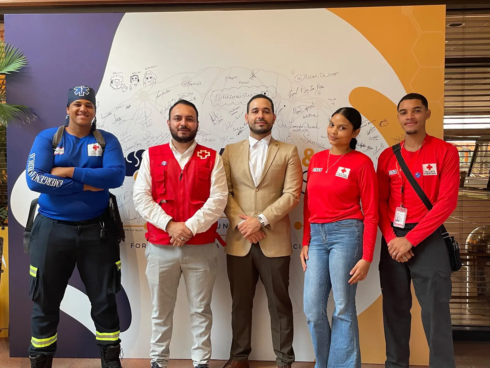 Voluntarios de la Cruz Roja Dominicana junto al equipo de AFMEC frente al mural de Hands & Minds Weekends
