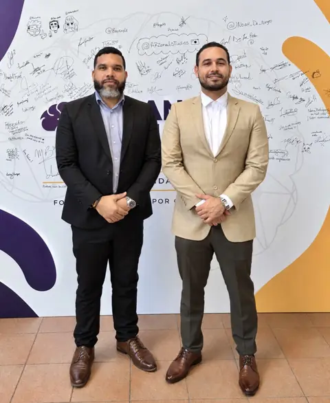 Representantes de AFMEC y de FUNDAPEC frente al mural de Hands & Minds Weekends