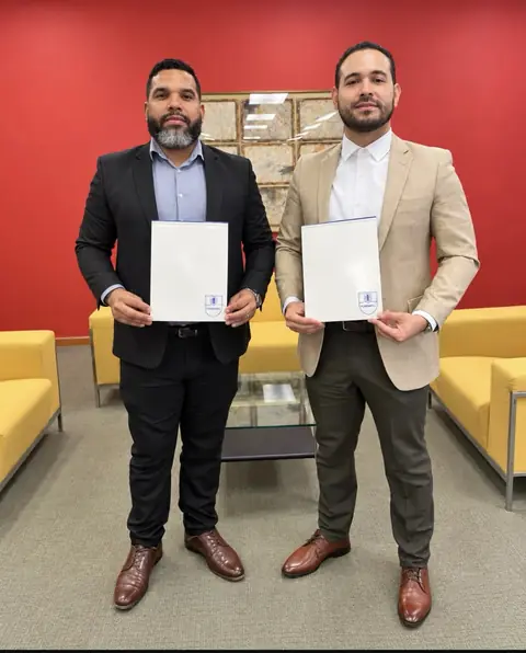 Representantes de AFMEC y de FUNDAPEC muestran las carpetas del convenio de financiamiento