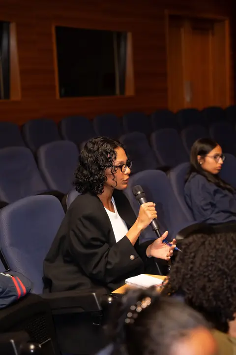 Participante hace una pregunta con micrófono desde su asiento