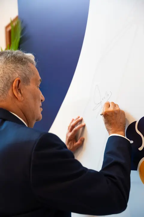 Invitado firma el mural de Hands & Minds Weekends