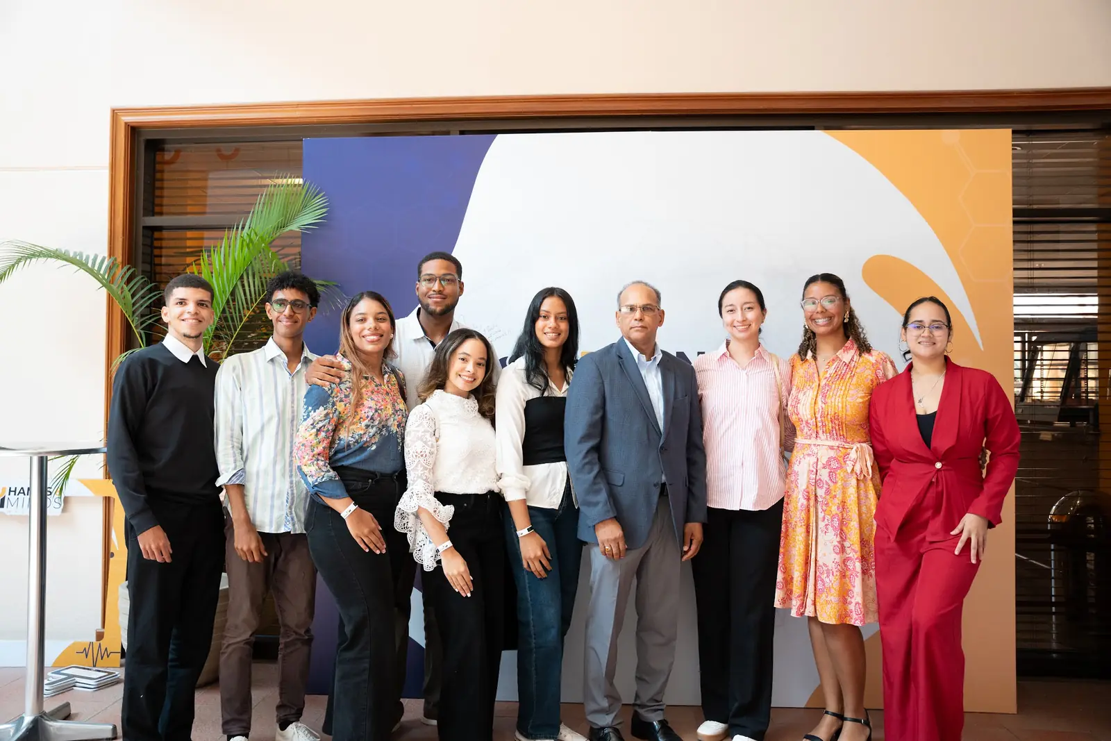 Organizadores e invitados posan en grupo frente al panel del evento