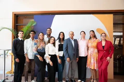 Organizadores e invitados posan en grupo frente al panel del evento