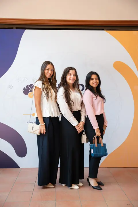 Tres participantes posan frente al panel de Hands & Minds Weekends